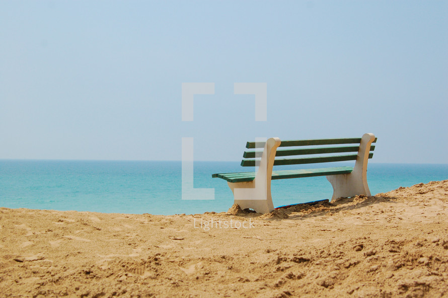 bench on a beach overlooking the ocean 