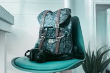 backpack and camera in a green office chair 
