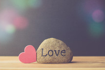 a rock with the word love and a red heart 