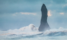 Waves crashing onto the shore of Reynisfjara, the black sand beach, with H..idrangur standing proud amongst the surf.