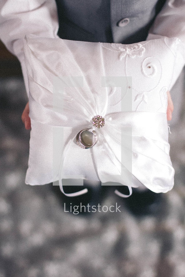 ring bearer holding a pillow with wedding rings