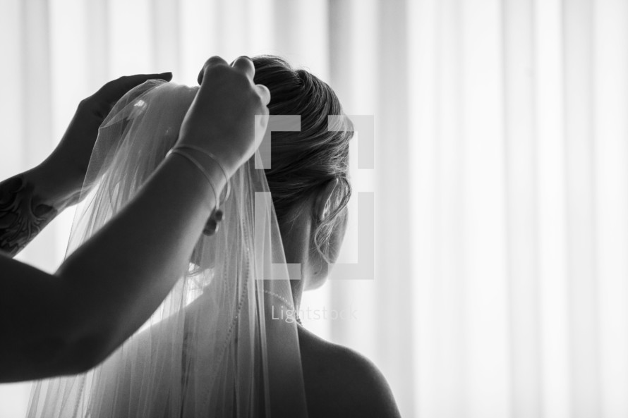 putting a veil on a bride 