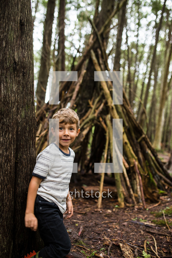 child with a teepee in the woods 