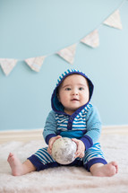 infant holding a globe