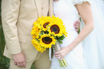 bride and groom and a bouquet of sunflowers 