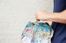 a man holding an apron covered in paint 