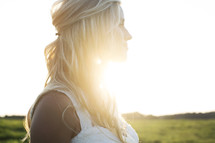 beautiful bride looking away in thought under intense sunlight. 