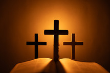Candlelight photo of a Bible and crosses