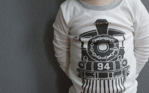 A child wearing a shirt with a train on the front.
