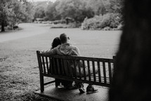 a couple sitting on a park bench 