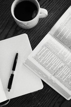 journal, pen, open Bible, and coffee mug on a table 