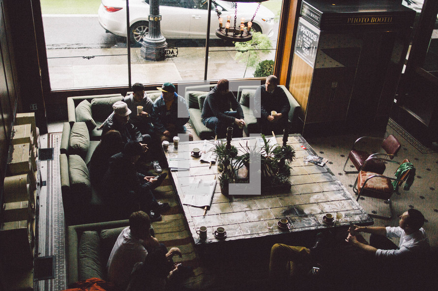 friends gathered around a table with coffee 
