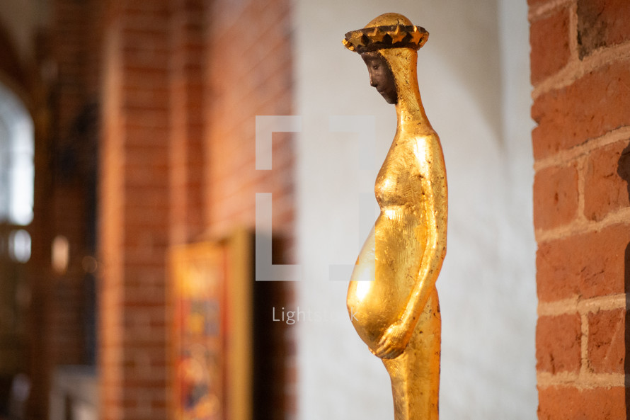 A statue of Virgin Mary in a cathedral environment 