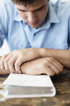 man in prayer over a Bible 