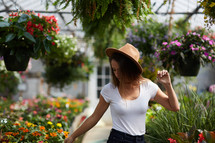 a woman standing in a greenhouse surrounded by plants 
