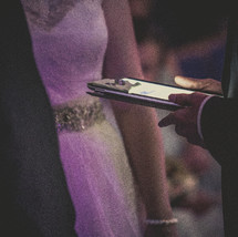 wedding rings presented to the bride and groom on an iPad 