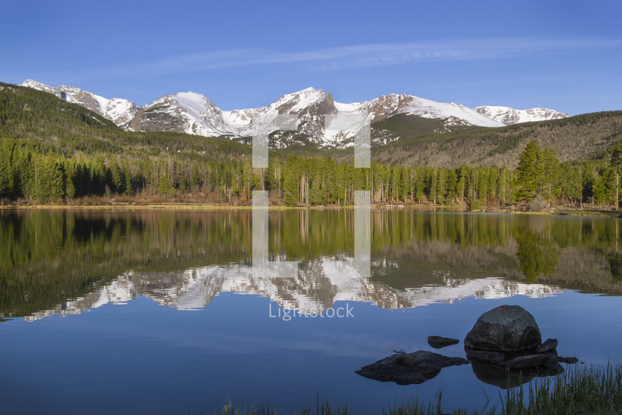 reflection of mountains on a pond water 