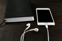 iPhone with earbuds and a Bible 