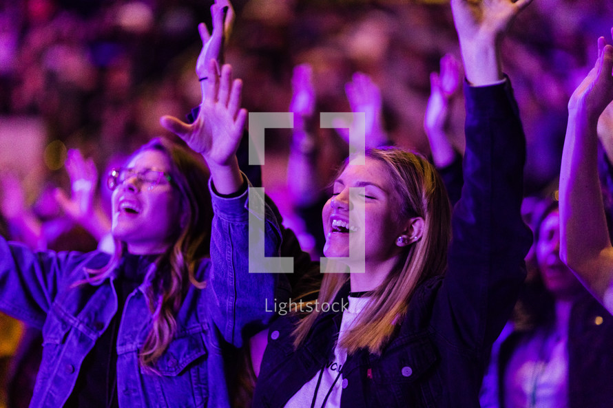 People in a church service with hands raised.