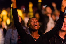 A woman with arms raised in praise and worship.