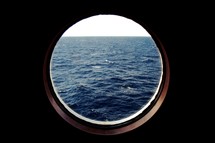 view of the ocean out a porthole window