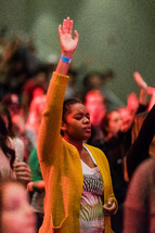a woman with hand raised during a worship service 