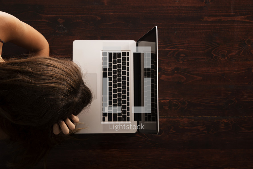 stressed woman in front of a laptop computer 