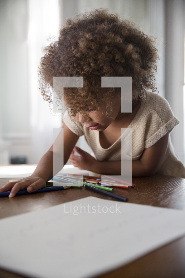 girl coloring at the kitchen table 