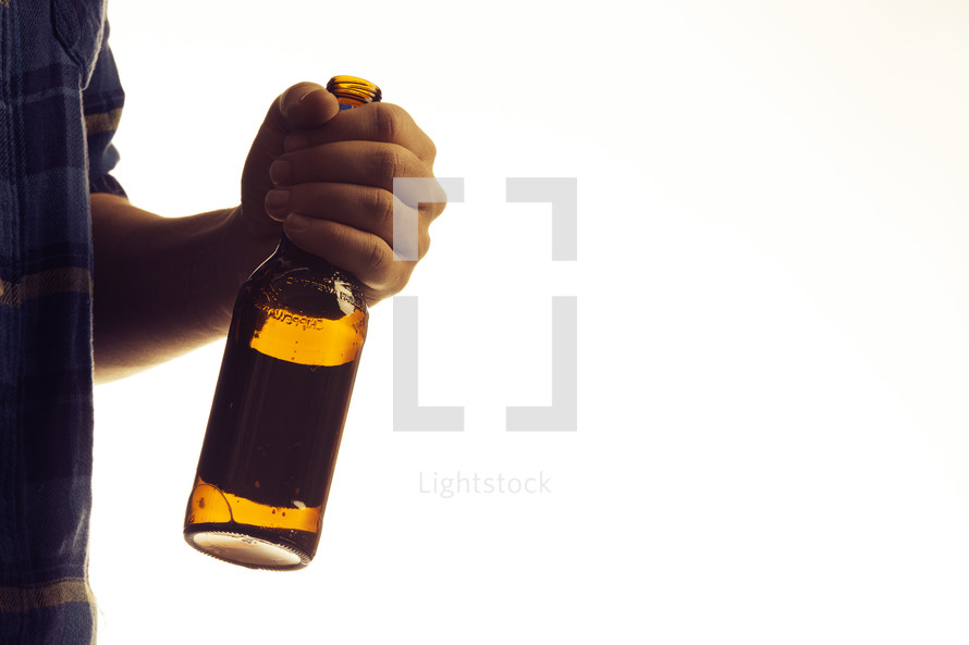 a man holding an empty beer bottle against a white background 