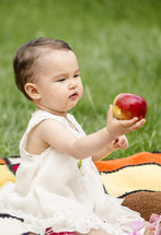 toddler girl eating a red apple 