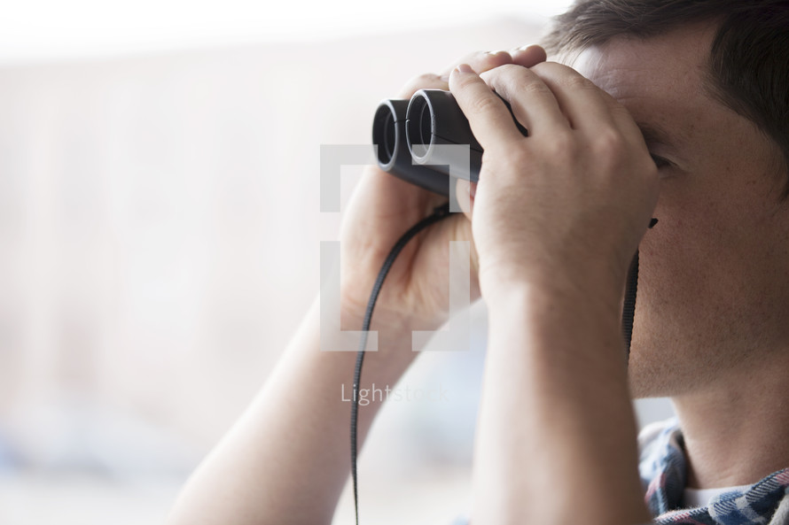 man looking through binoculars 