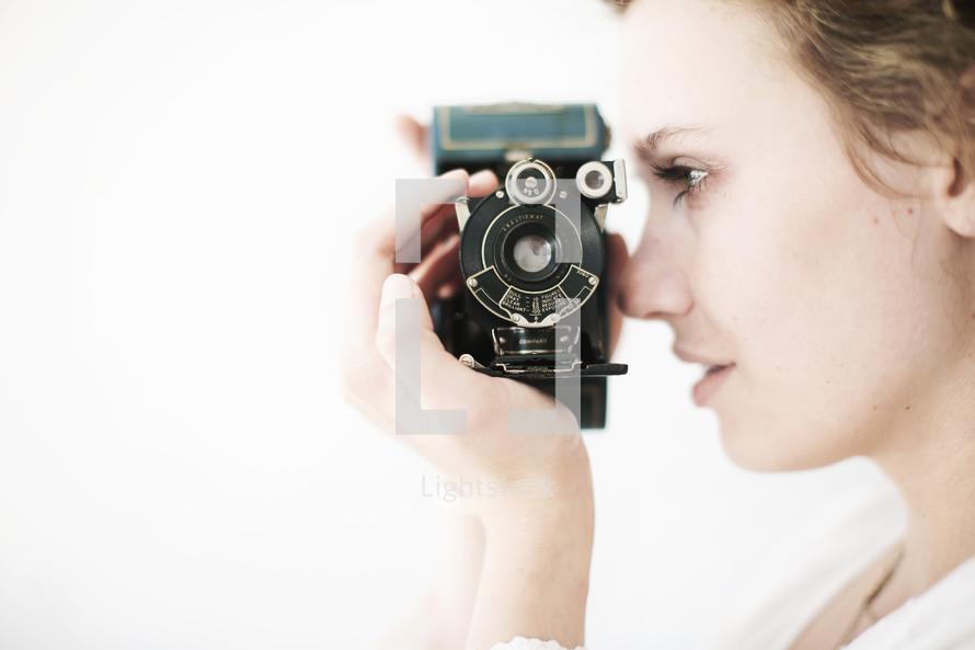 Woman taking a photo with a vintage camera.