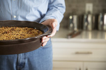 a man holding a casserole 