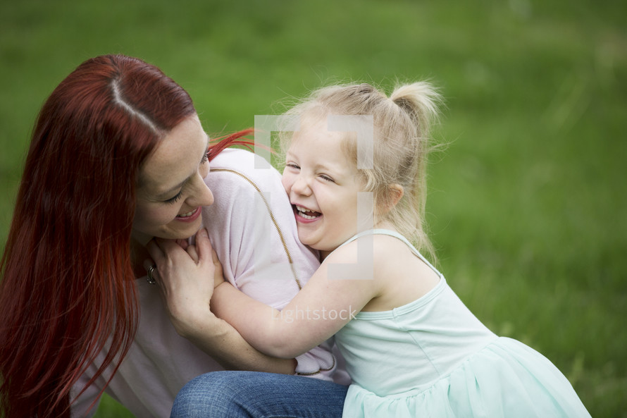 A mother and daughter playing together outdoors.