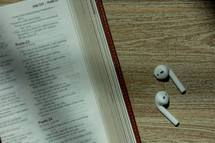 earbuds and pages of a Bible 