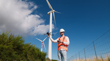 Engineer is using a drone to check wind power plant