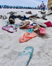 many flips flops in the sand on the beach 