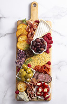 Savory Charcuterie Board Covered in Meats Olives Peppers Berries and Cheese