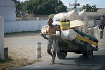 man pulling a cart full of goods 