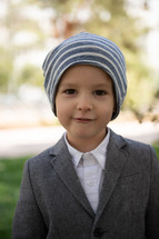 portrait of a boy in dress clothes and knit cap 