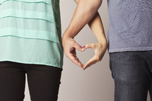 A couple making heart hands.