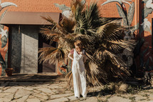 portrait of a woman standing outdoors in front of palm trees