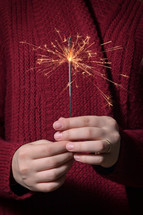a woman holding a sparkler 
