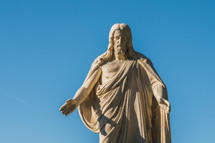Stone statue of Jesus with clear, blue sky