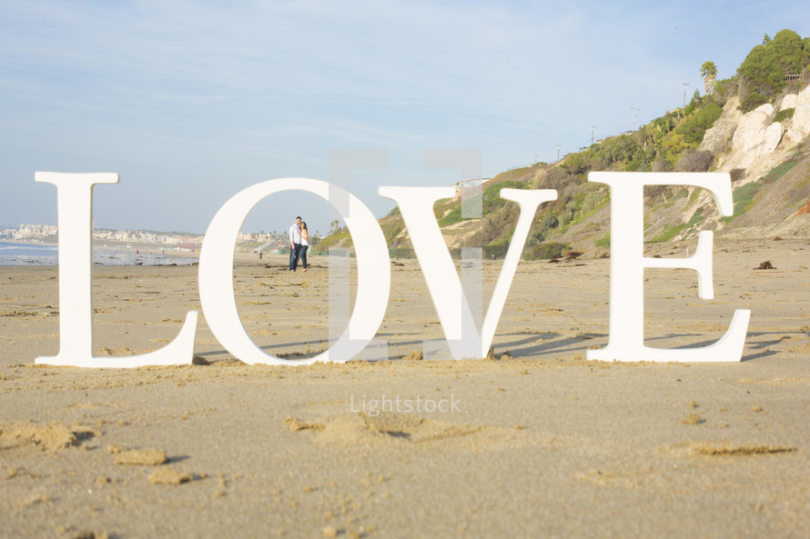 couple on a beach and the word LOVE