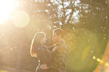 couple hugging under the glow of sunlight