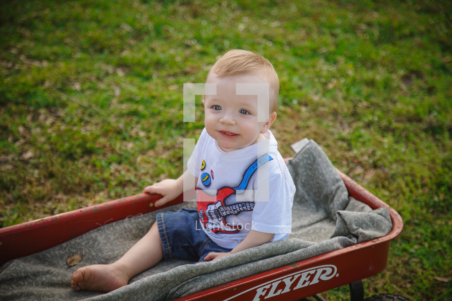 toddler boy in a red wagon 
