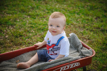 toddler boy in a red wagon 