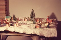 mini Christmas village on top of an old television set 