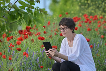 a woman reading scripture in a field of wildflowers 